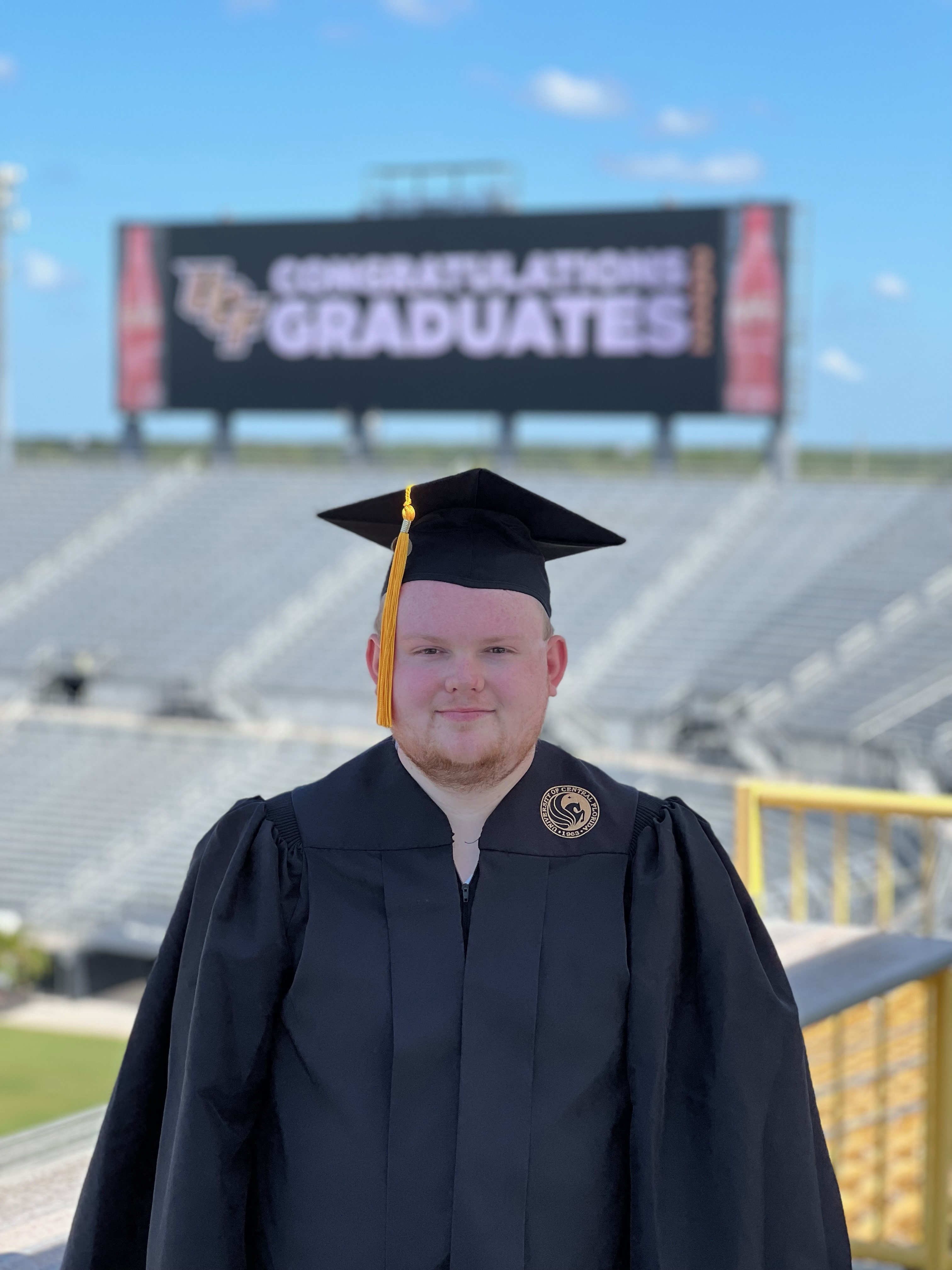 Picture of Dylan Krueger in graduation cap and gown at University of Central Florida.